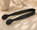 Black metal tongs with a matte finish, featuring 'SUS 304' stamped on one arm and a laser-engraved logo of two fish with the word 'MUTLA' on the other.